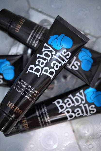 Multiple tubes of 'Baby Balls' hair removal cream on a reflective surface